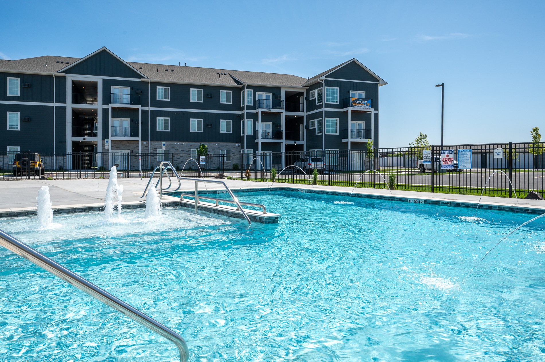 A swimming pool in front of a multi-story building.